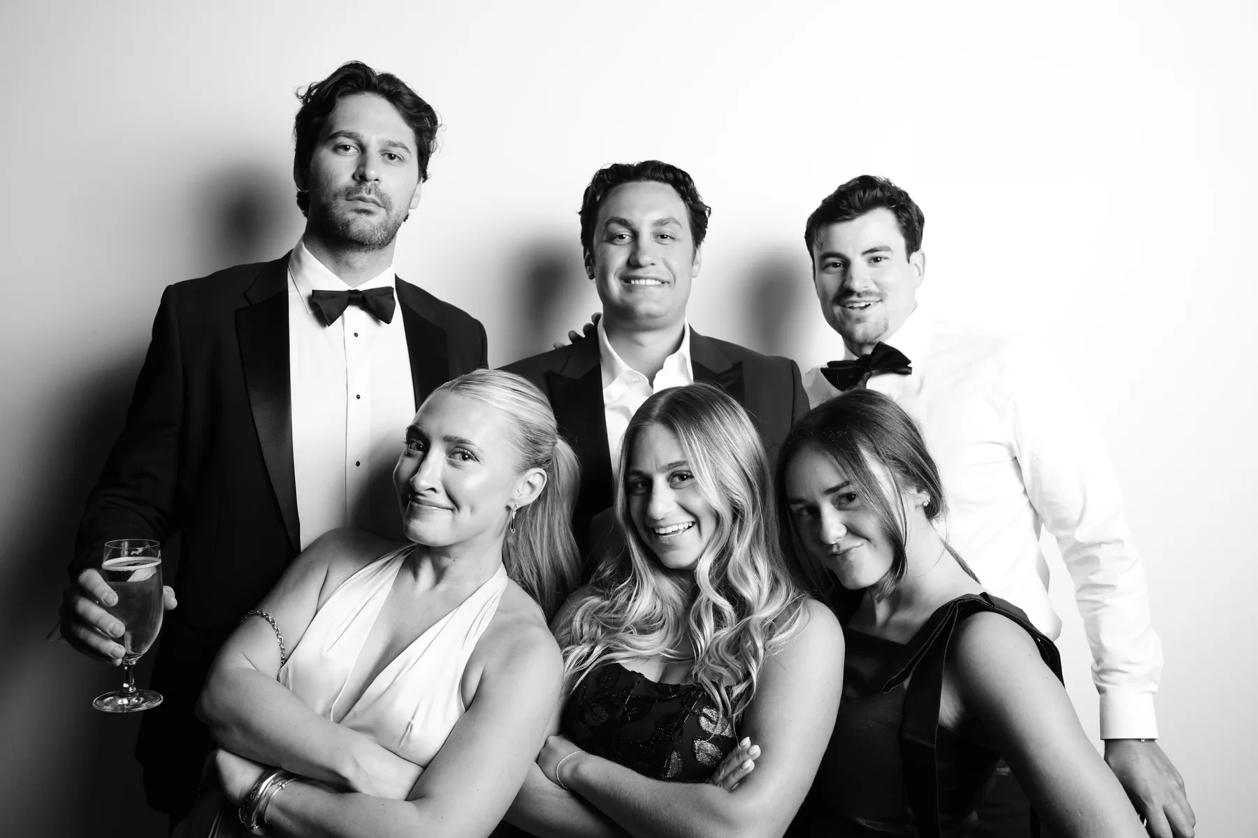 Six wedding guests gathered for a black-and-white studio portrait