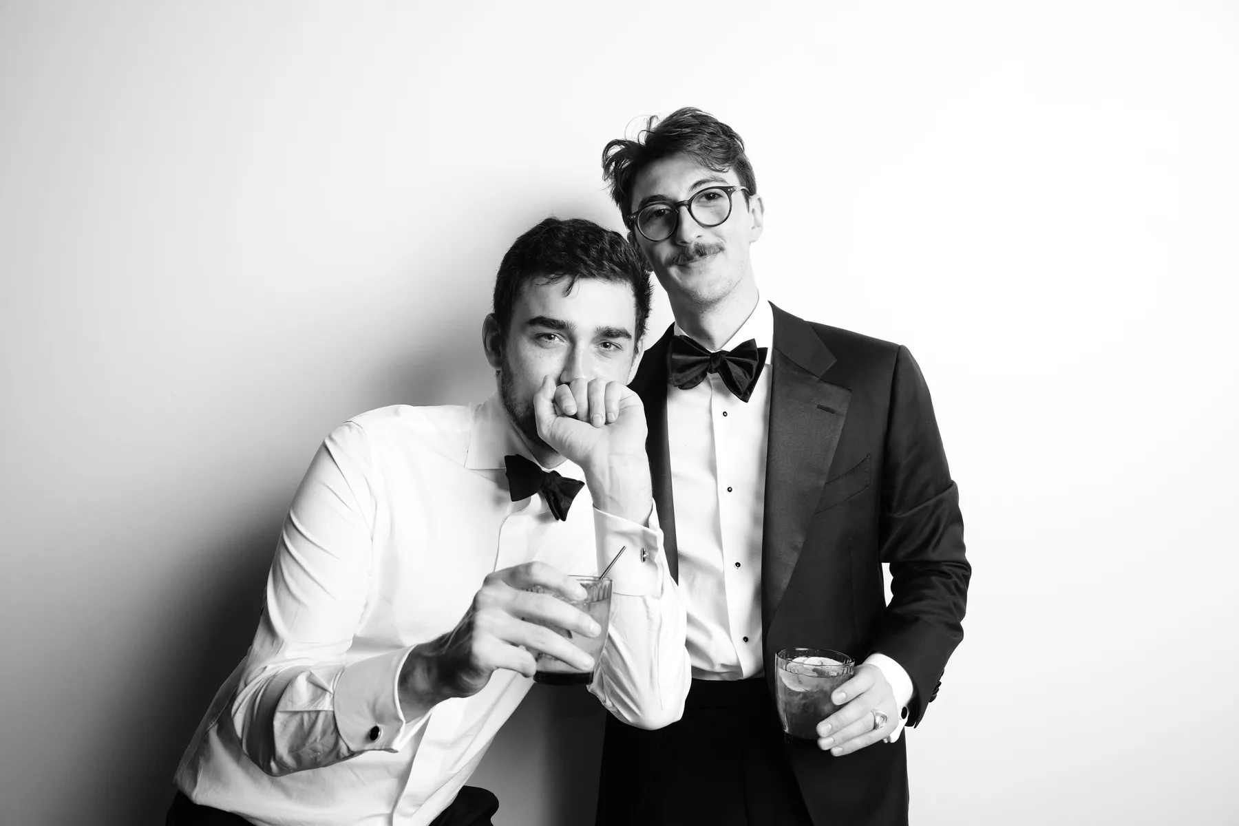 Two wedding guests posing with playful expressions