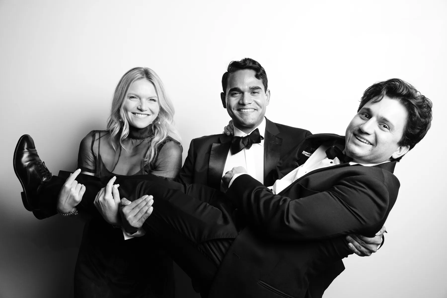 Three wedding guests creating a playful group portrait