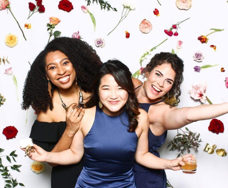 Wedding guests at Legacy Booth with floral backdrop