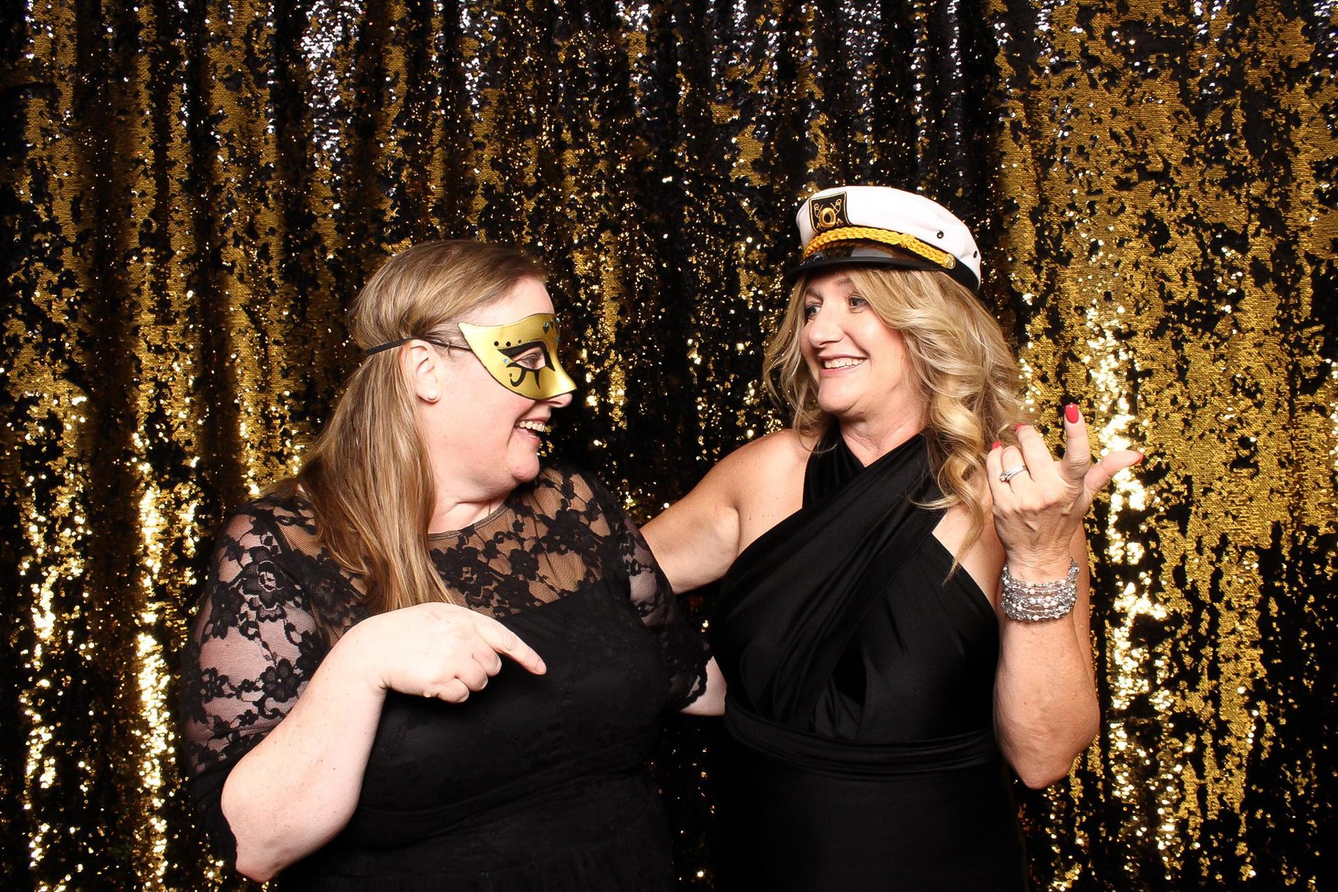 Friends posing at Legacy Booth with sequin backdrop